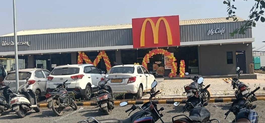 Opening day at McDonald's on Ring Road, Bhavnagar with balloon arches and vehicles parked outside